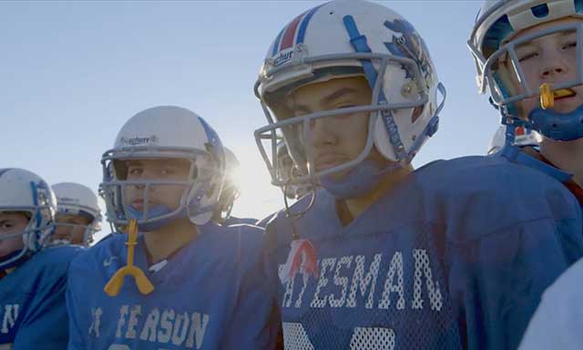 Middle school football players on a field revitalized by Fields & Futures
