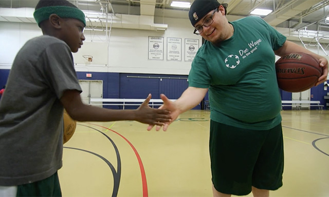 A Doc Wayne Chalk Talk participant shaking hands with a coach during a sports therapy session in Boston