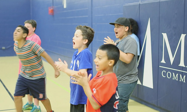 Boston youth cheering during a Doc Wayne Chalk Talk sports therapy program