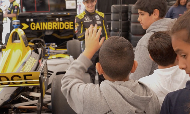 IndyCar Driver Zach Veach engaging with students during an Endeavor STEM program field trip at the race track.