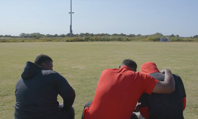 Josh Norman is seen embracing his students during the Coaching Against the Odds segment of Season 3, Show 4 of the Power of Sports.
